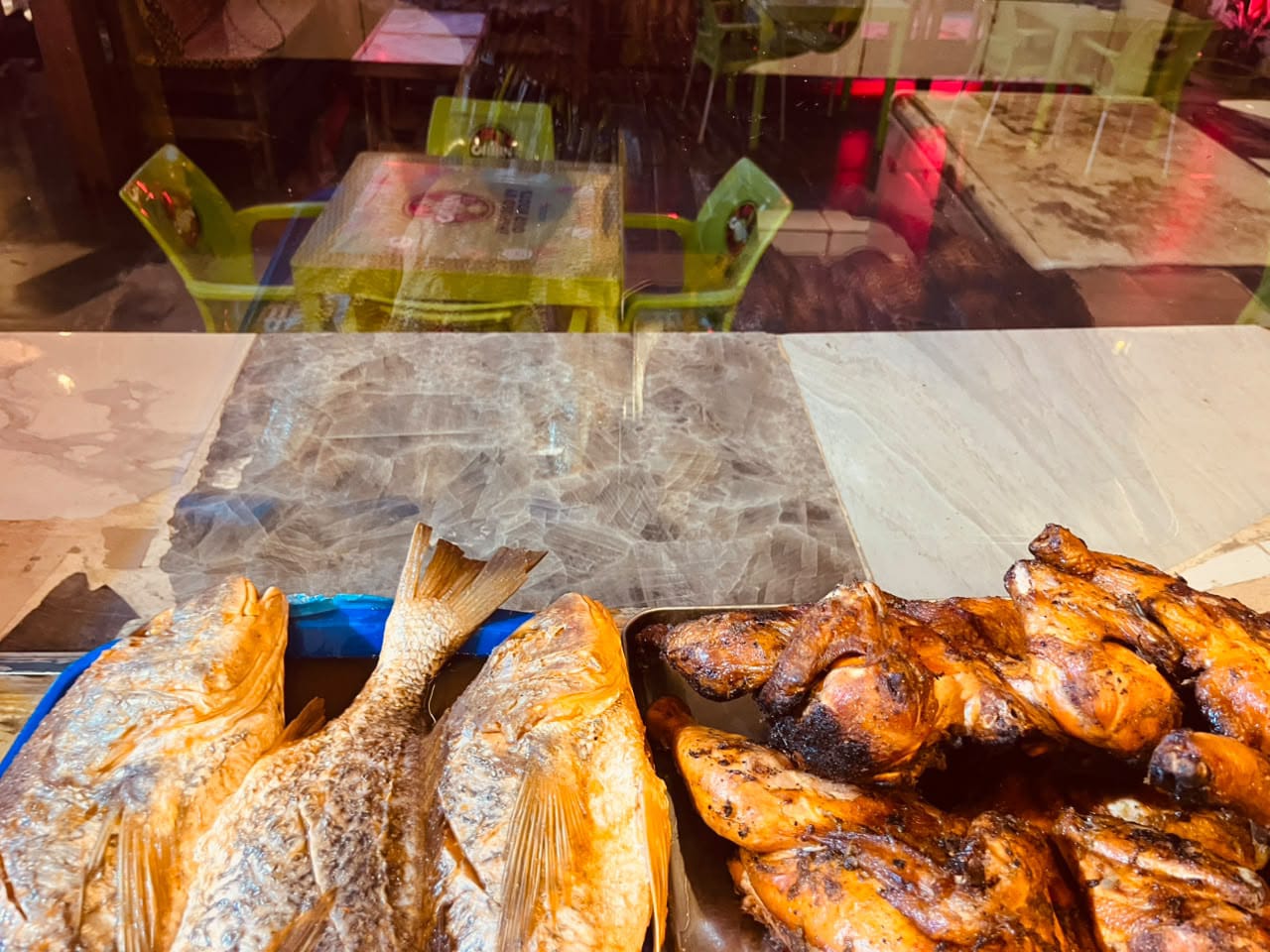 Smoked fish and grilled chicken on display at the counter